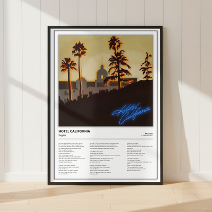 A framed poster of Hotel California leaning against a white paneled wall on a light wood floor, with soft sunlight casting shadows across the scene.