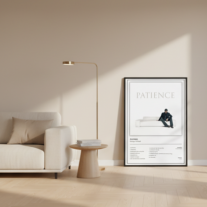 A framed minimalist music poster for George Michael's album 'Patience' leaning against a white paneled wall on a light wood floor, with soft window shadows cast across the scene.