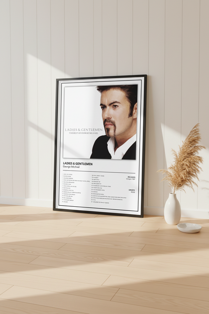 A framed music poster of George Michael's album 'Ladies & Gentlemen' leaning against a white paneled wall on a light wood floor, with soft sunlight casting shadows.