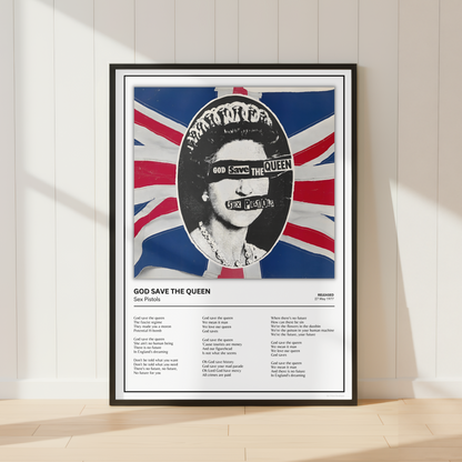 A framed music poster of Queen's 'God Save the Queen' leaning against a white paneled wall on a light wood floor, featuring a stylized portrait over a Union Jack background.