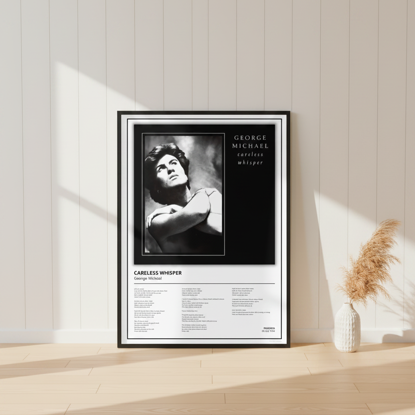 A framed black-and-white music poster for George Michael's song 'Careless Whisper' leaning against a white paneled wall on a light wood floor, with soft sunlight casting shadows across the scene.
