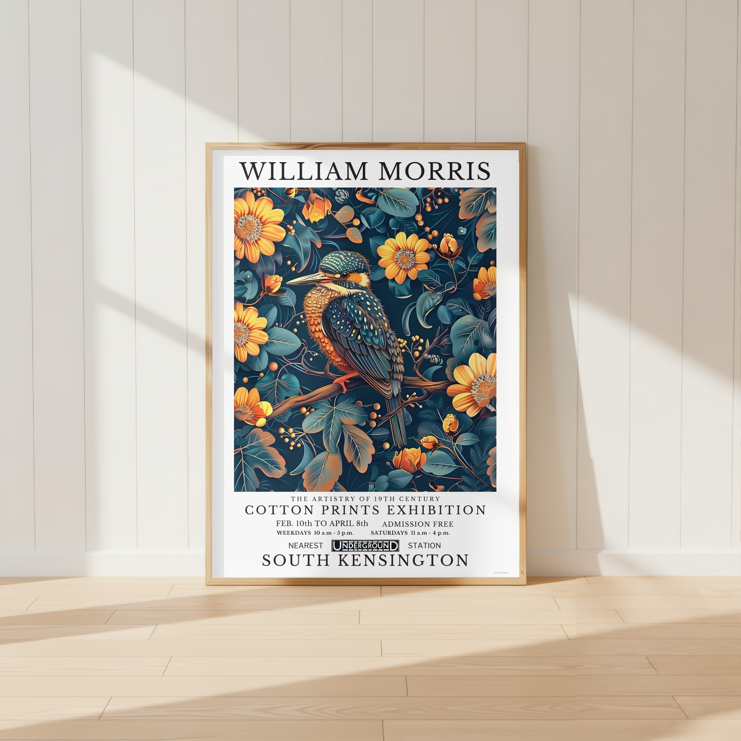 William Morris inspired kingfisher print displayed above a wooden desk in a neutral home office with botanical decor and warm natural lighting.