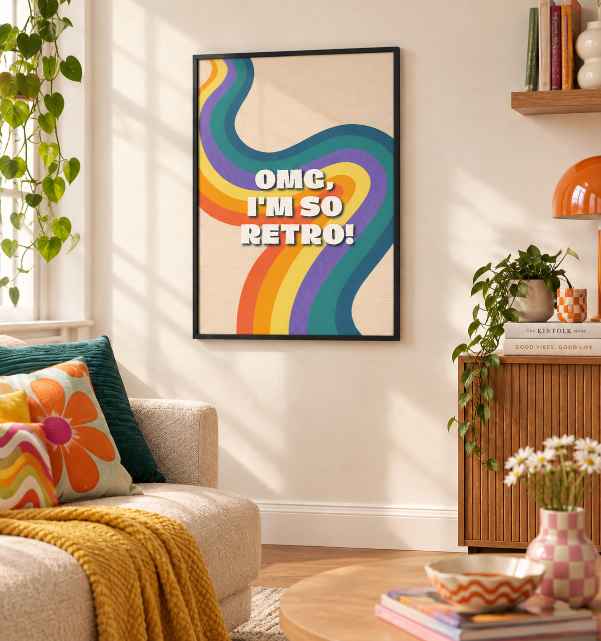 A framed retro-style wall art print hangs on a beige wall in a styled living room. The print features bold white text reading 'OMG, I'M SO RETRO!' over flowing multicolor wavy lines in rainbow hues on a cream background.