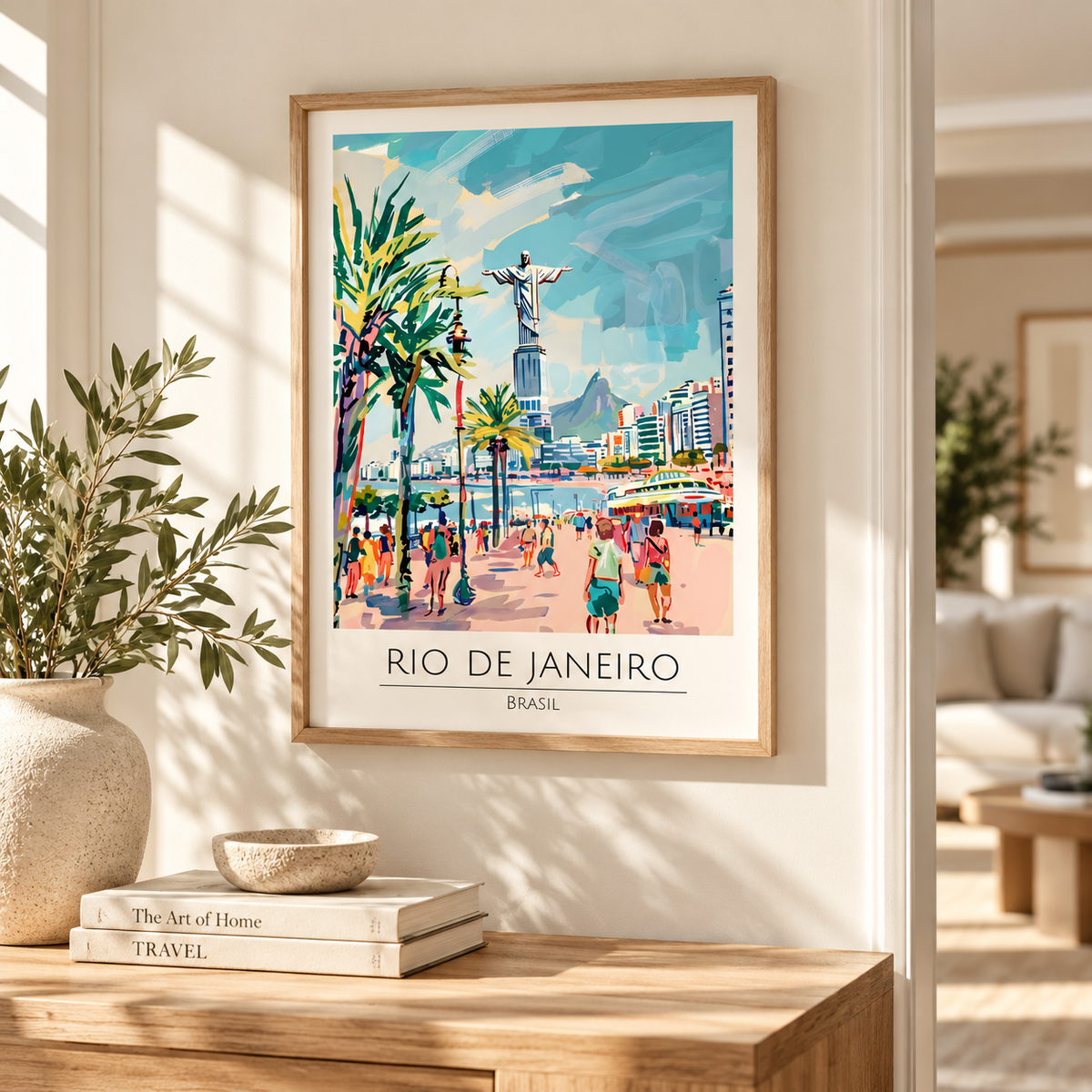 A framed travel poster of Rio de Janeiro, Brazil, hanging on a warm beige wall in a beautifully styled living room. The poster features a colorful illustration of the city with palm trees, a beach crowd, and the Christ the Redeemer statue, enclosed in a light wood frame.