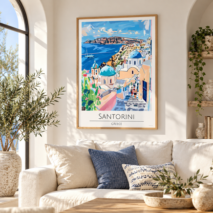 A framed Santorini Greece travel poster with a colorful coastal illustration hangs on a light beige wall above a cream-colored sofa in a styled living room.