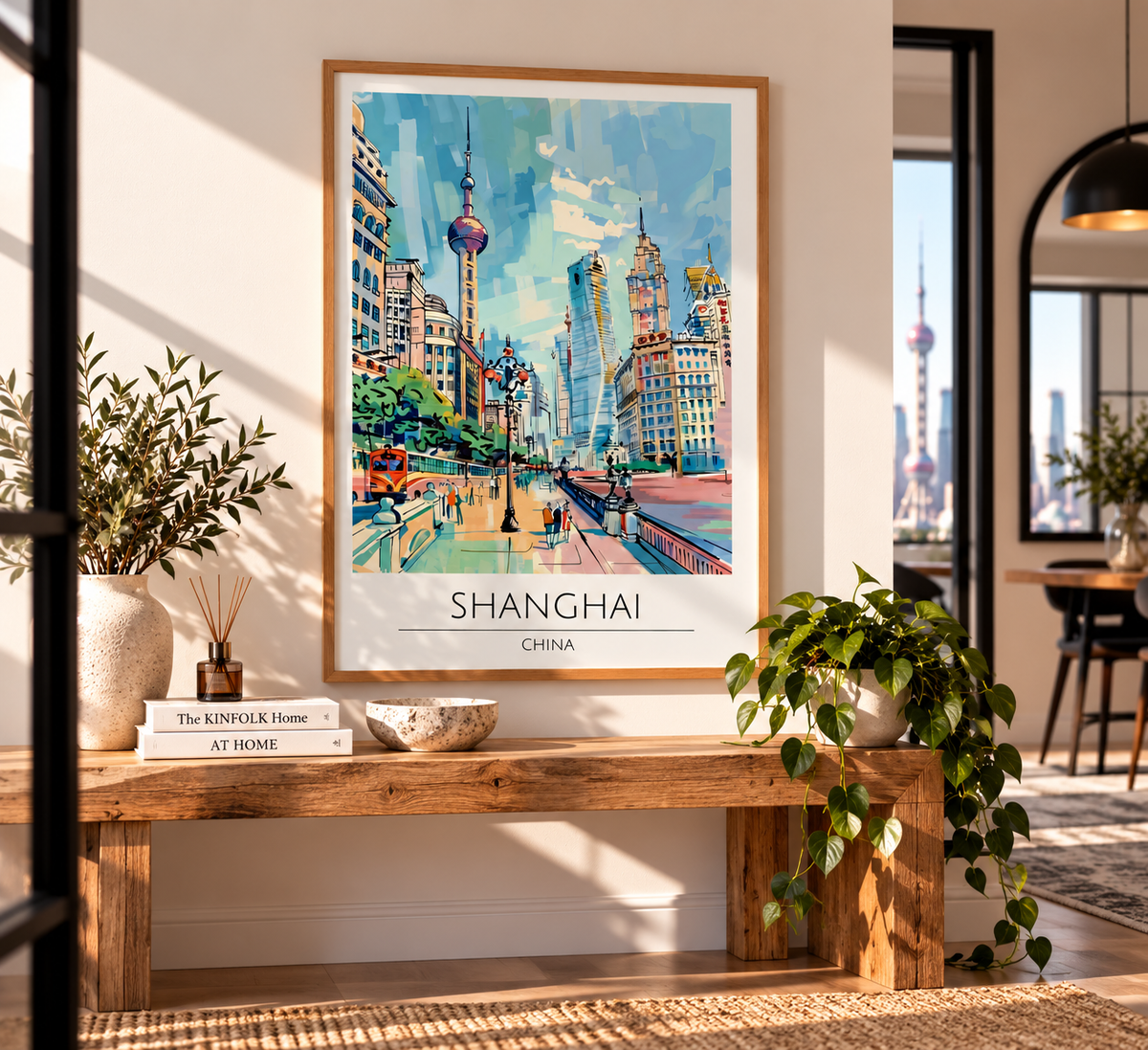 A framed art print of a colorful Shanghai cityscape hangs on a beige wall above a rustic wooden bench in a styled living room setting with plants and books.