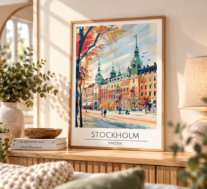 A framed travel poster of Stockholm, Sweden, displayed on a wooden console table in a cozy, sunlit room. The poster features a colorful watercolor illustration of the city's architecture and autumn trees, with 'STOCKHOLM SWEDEN' printed at the bottom.